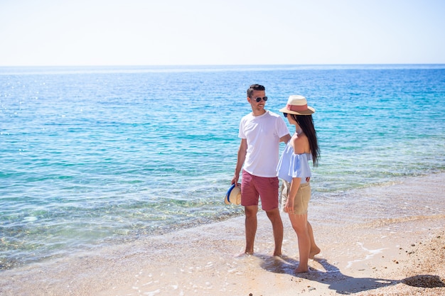 casal feliz em óculos de sol na praia