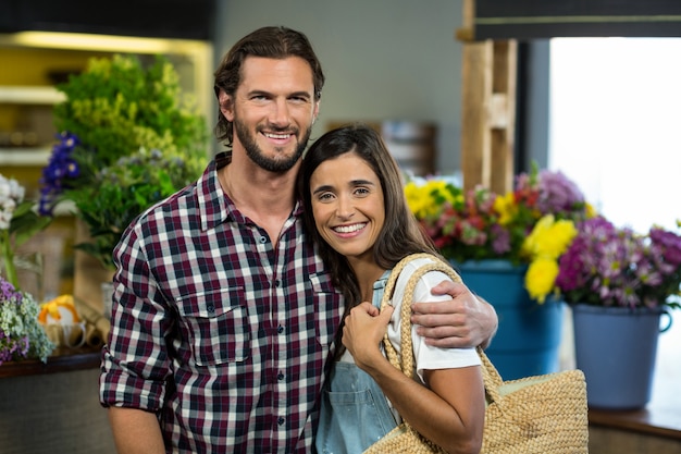 Casal feliz em pé na floricultura