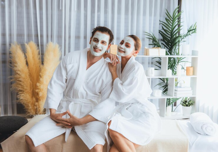 Foto casal feliz em roupão de banho com máscara de creme facial tranquilo