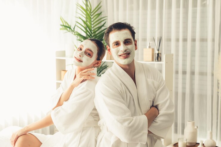 Foto casal feliz em roupão de banho com máscara de creme facial tranquilo