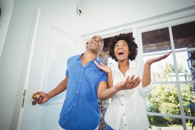 Casal feliz entrando em sua casa e torcendo