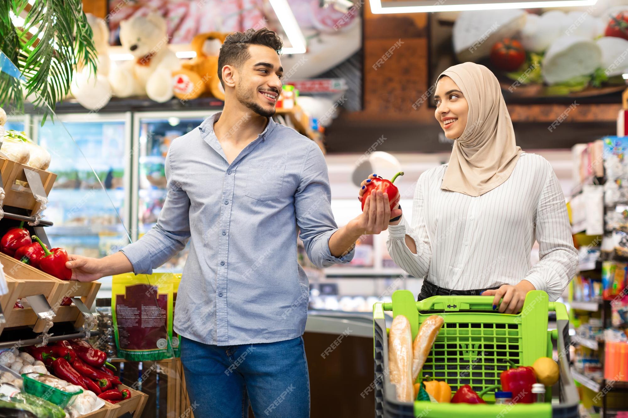 Casal feliz família muçulmana em compras de supermercado