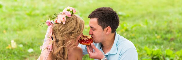 Casal feliz fazendo piquenique romântico no campo.