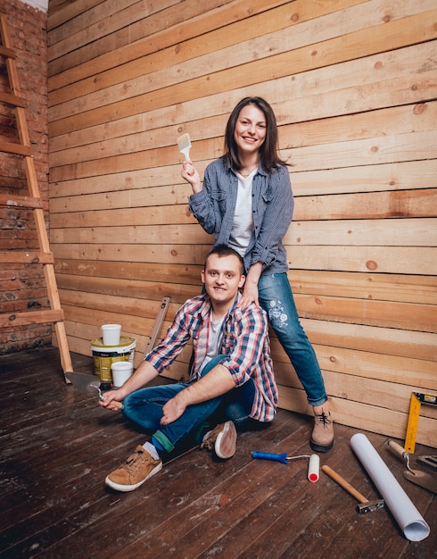 Casal feliz fazendo reparos em sua casa.