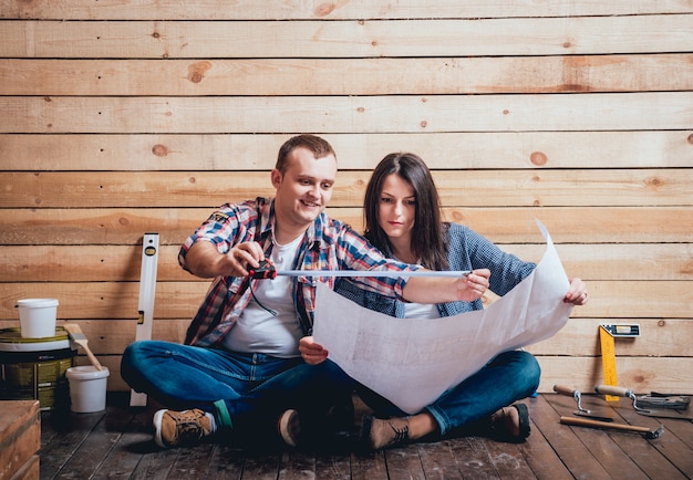 Foto casal feliz fazendo reparos em sua casa.