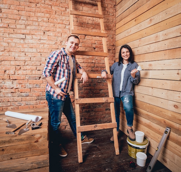 Casal feliz fazendo reparos em sua casa.