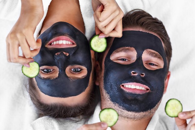 casal feliz fazendo tratamento facial no salão spa