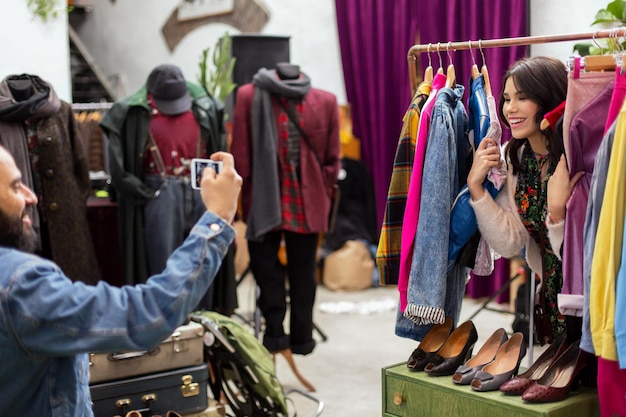 Foto casal feliz fotografando em loja de roupas