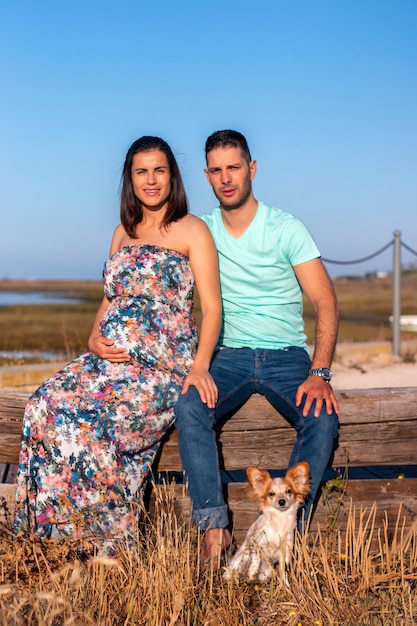 Casal feliz grávida com cachorro pequeno