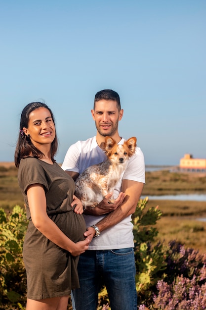 Foto casal feliz grávida com cachorro pequeno