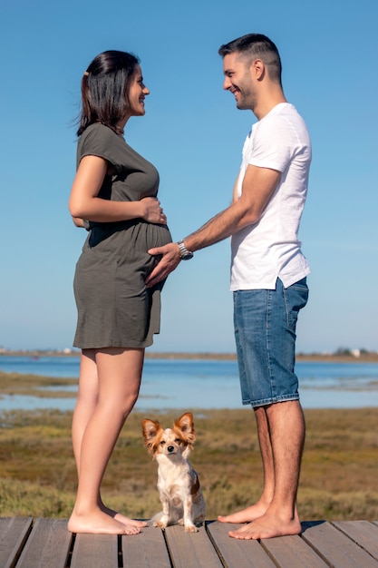 Casal feliz grávida com cachorro pequeno