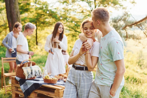 Casal feliz Grupo de jovens tem férias ao ar livre na floresta Concepção de fim de semana e amizade