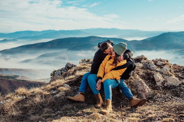 Casal feliz homem e mulher turista no topo da montanha durante uma caminhada no verão