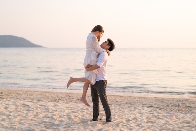 Casal feliz indo lua de mel viaja na praia de areia tropical no verão