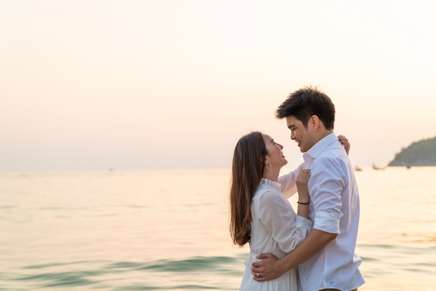 Casal feliz indo lua de mel viaja na praia de areia tropical no verão