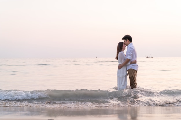 Casal feliz indo lua de mel viaja na praia de areia tropical no verão