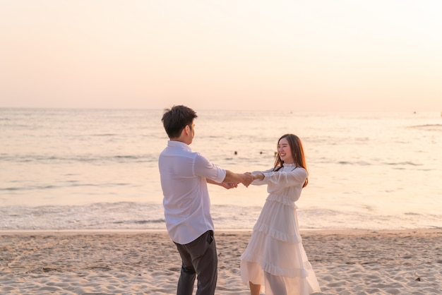 Casal feliz indo lua de mel viaja na praia de areia tropical no verão