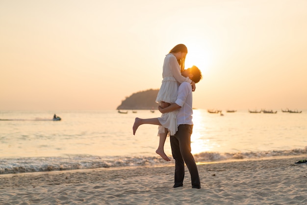 Casal feliz indo lua de mel viaja na praia de areia tropical no verão