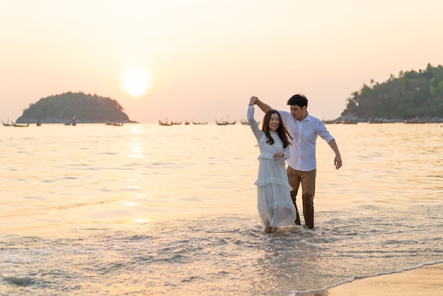 Casal feliz indo lua de mel viaja na praia de areia tropical no verão