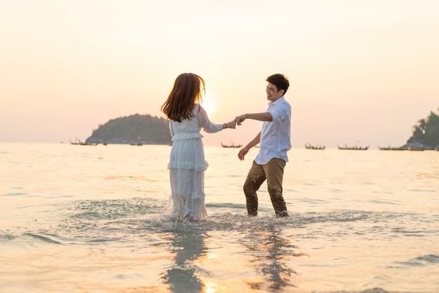 Casal feliz indo lua de mel viaja na praia de areia tropical no verão