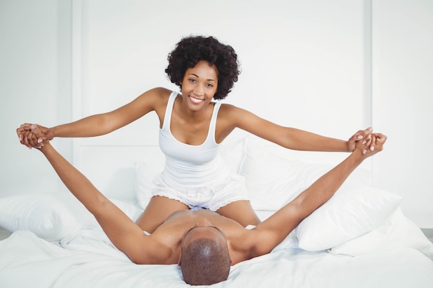 Casal feliz jogando na cama em casa