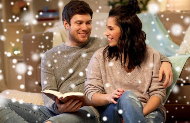 casal feliz lendo um livro em casa