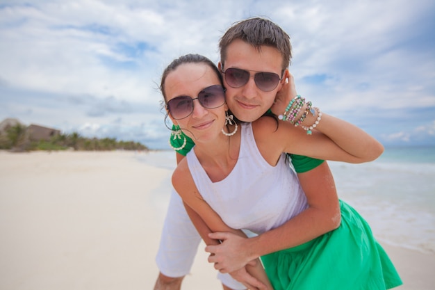 Casal feliz na praia exótica, olhando para a câmera