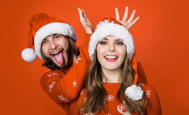 Casal feliz nas férias de natal família em chapéus de papai noel se divertindo emoções de relacionamentos