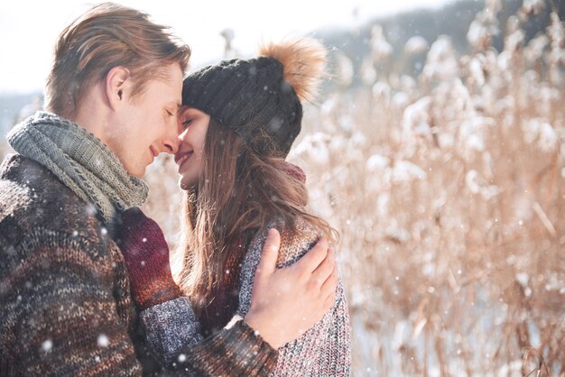 Casal feliz no amor abraça na floresta de inverno nevado frio