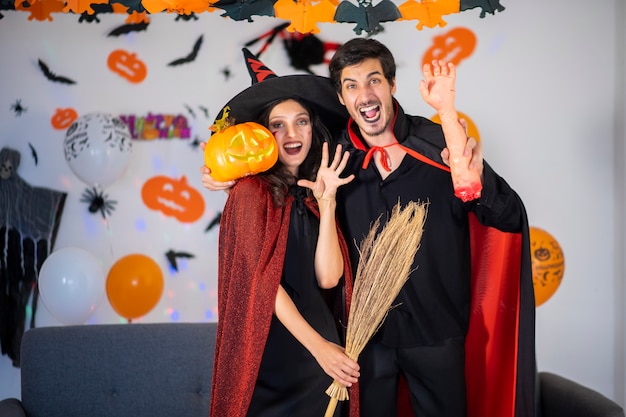 Casal feliz no amor em fantasias e maquiagem em uma celebração do Halloween