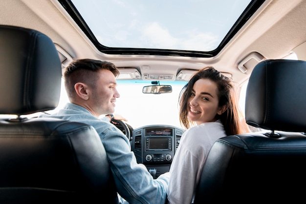 Foto casal feliz no carro com tiro médio