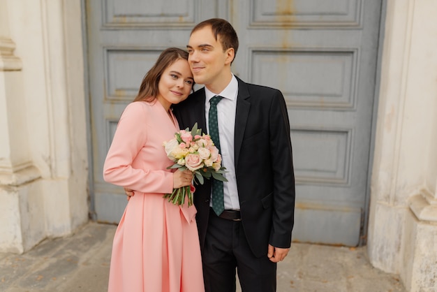 Casal feliz noivos perto da porta da igreja.