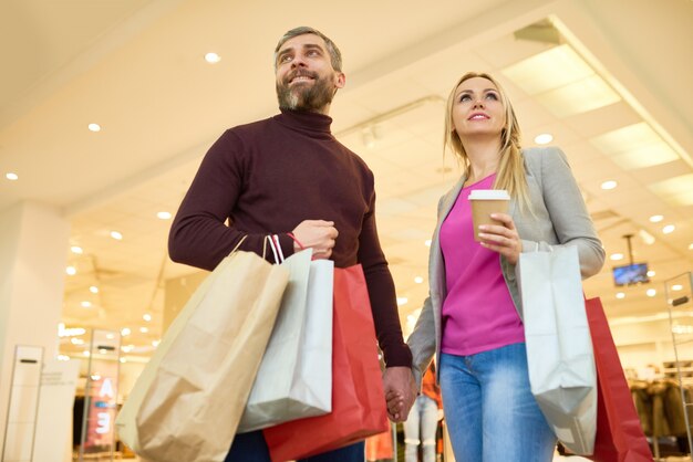 Casal feliz olhando para exibe no shopping