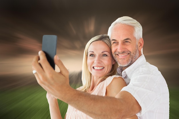 Casal feliz posando para uma selfie contra o céu tempestuoso sobre a cidade