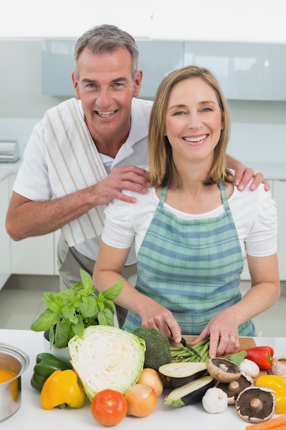 Casal feliz preparando comida juntos na cozinha