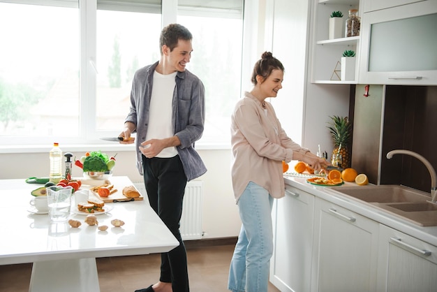 Casal feliz preparando o jantar juntos cortando vegetais comidas orgânicas