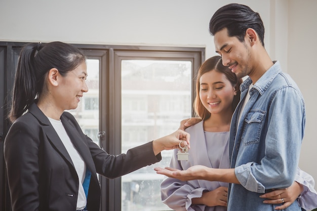 Casal feliz, recebendo a chave do apartamento do agente imobiliário