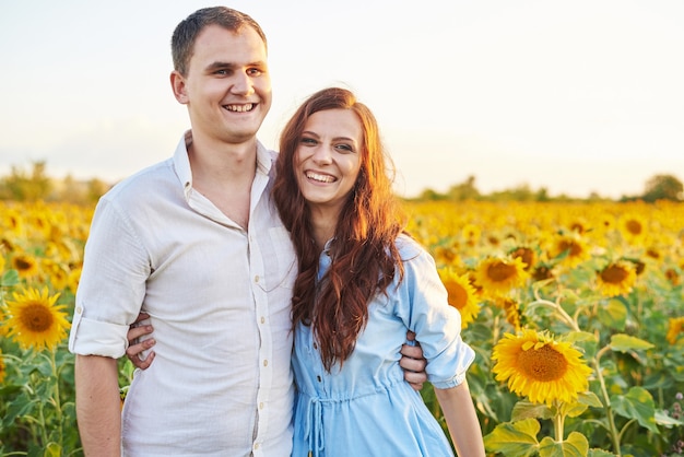 Casal feliz recém-casado sorrindo em um campo de girassóis