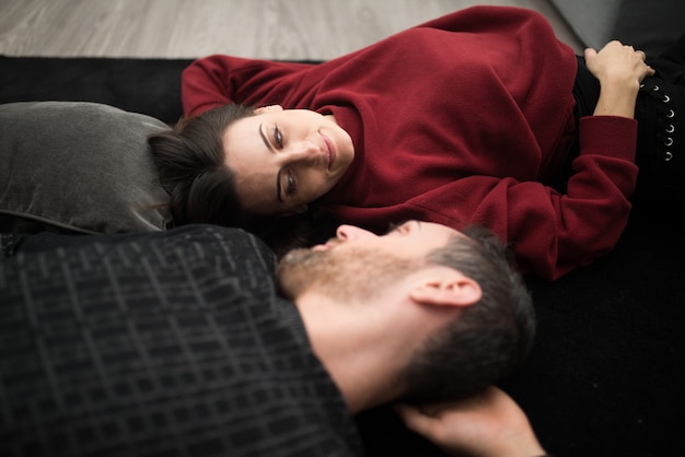 Casal feliz relaxando em um tapete em casa