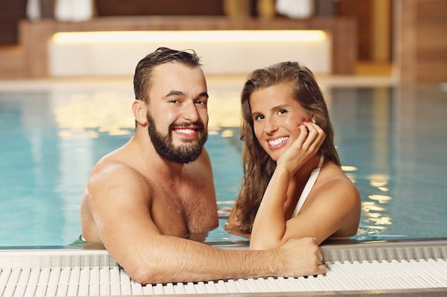 casal feliz relaxando no spa da piscina
