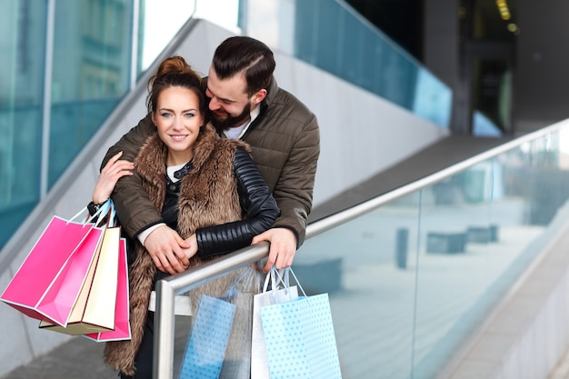 casal feliz se abraçando enquanto faz compras