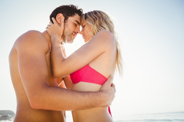 Casal feliz se abraçando na praia