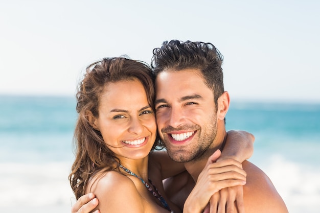 Casal feliz se abraçando na praia