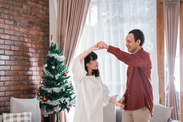 Casal feliz se amando dançando no dia de natal em casa