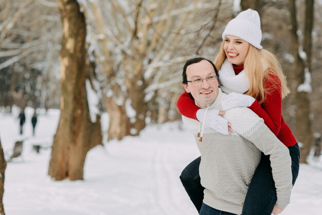Casal feliz se divertindo ao ar livre no parque de neve.