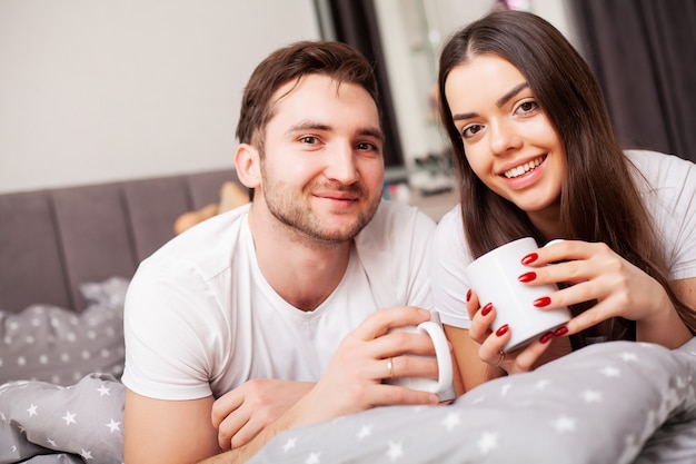 Casal feliz se divertindo na cama. íntimo, sensual, par jovem, em, quarto, desfrutando, um ao outro