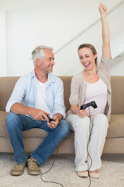 Casal feliz se divertindo no sofá jogando videogames