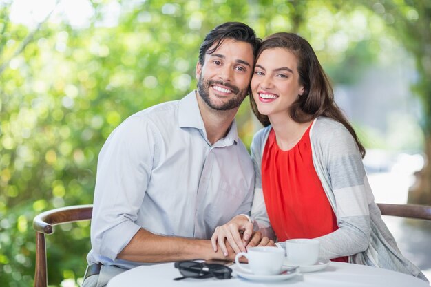 Casal feliz, segurando as mãos no restaurante