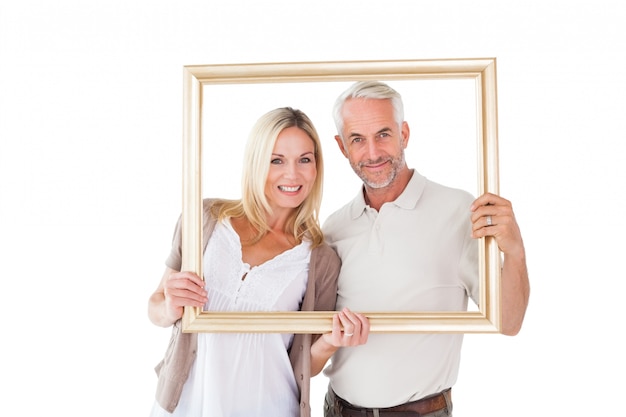 Casal feliz segurando um quadro de imagem