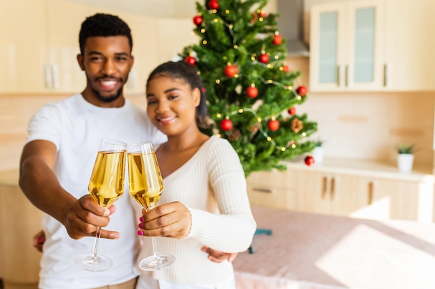 Casal feliz segurando uma taça de champanhe e comemorando o ano novo em casa